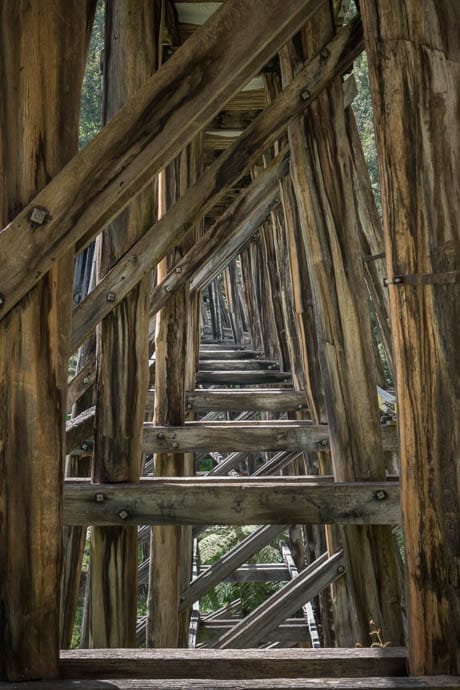 Portrait image showing the cross over of trestles underneath the bridge