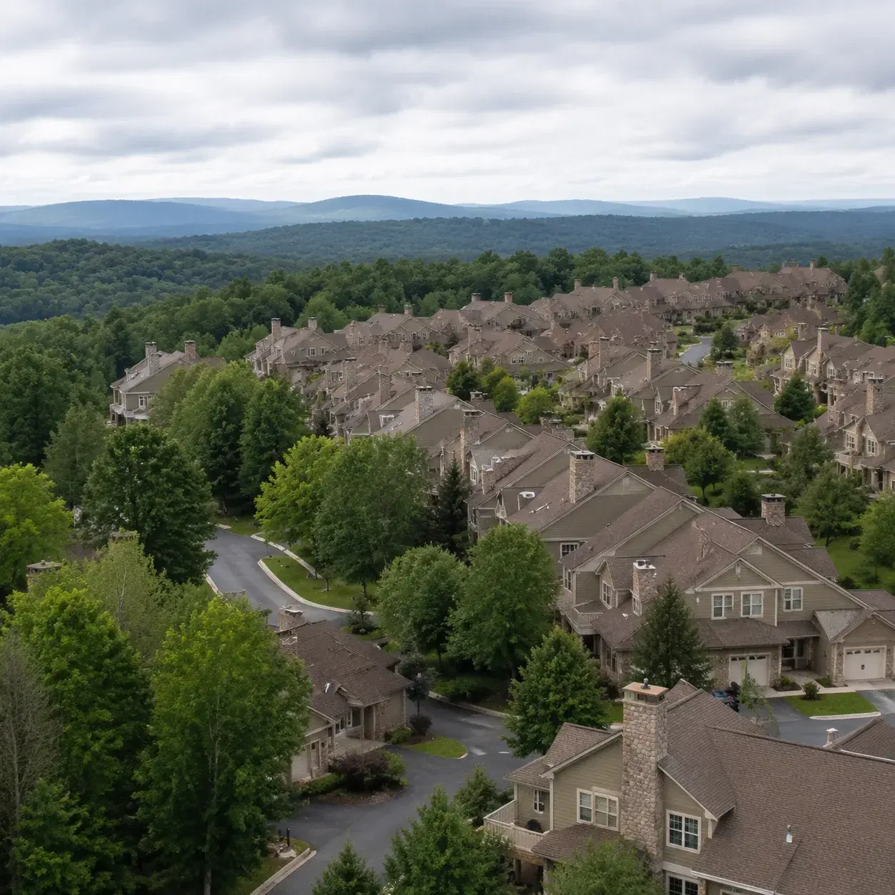 Realistic editorial photo of a large Westchester condo community with hills, attached homes, mature trees, and winding r