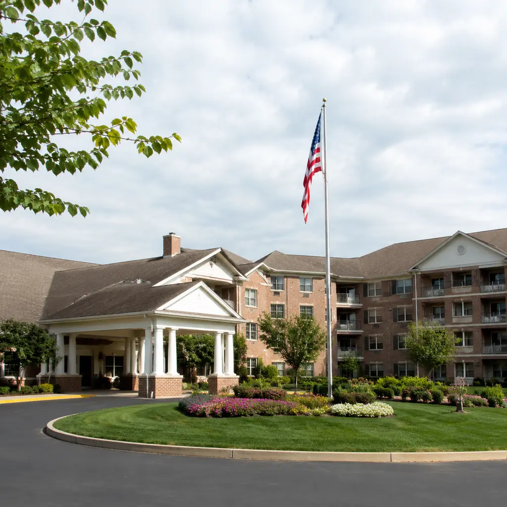 Realistic editorial photo of a suburban Columbus retirement community with brick apartment wings, manicured lawns, flagp