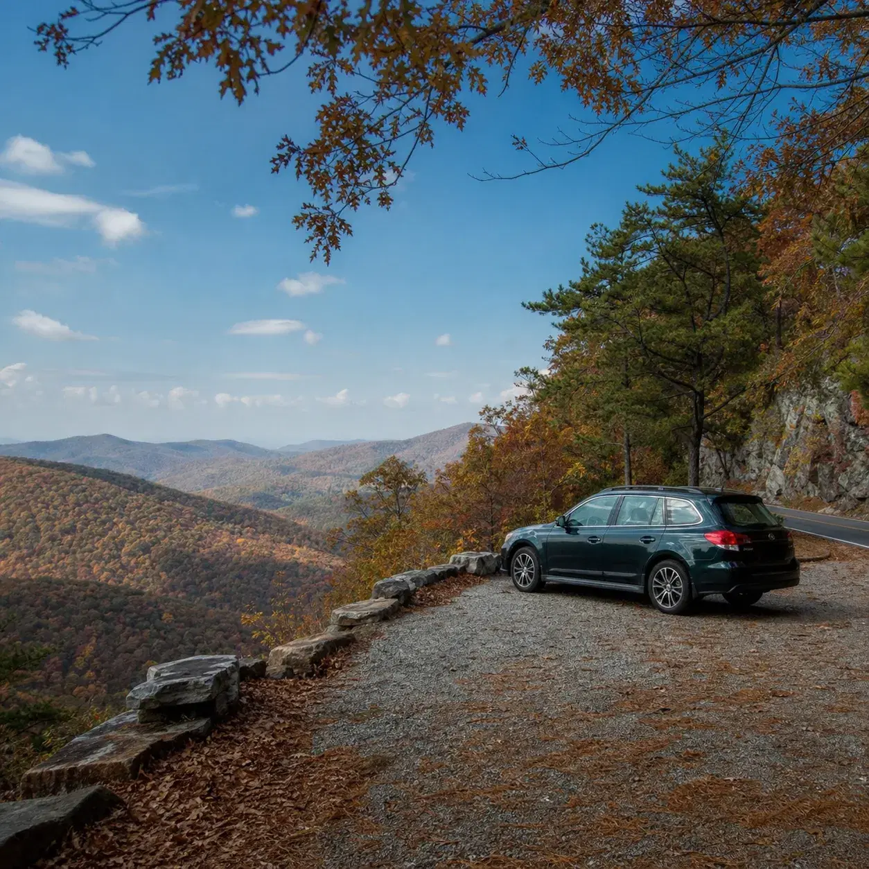 Realistic editorial photo of a ridge road through the Ouachita Mountains with a quiet overlook, autumn-colored forest, a