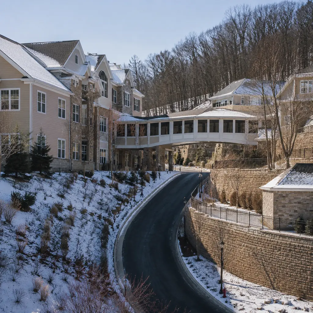 Realistic editorial photo of a hillside Pennsylvania retirement community with multi-story residential buildings connect