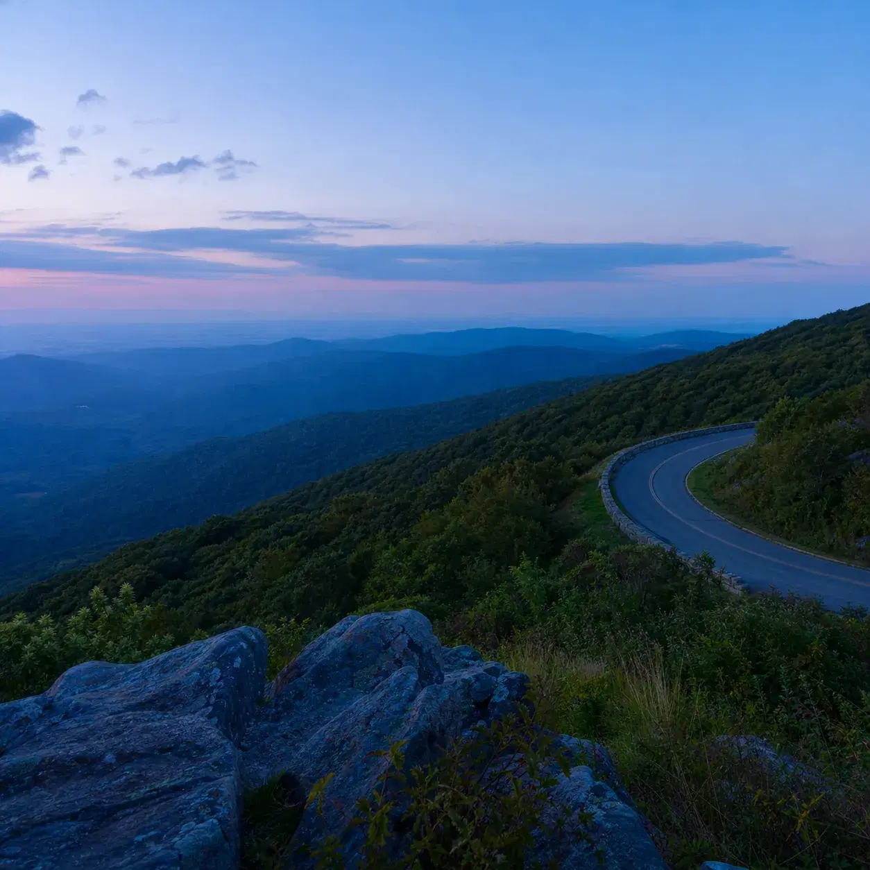 Realistic editorial photo of Skyline Drive in Shenandoah National Park with a mountain overlook, layered ridges, and a c