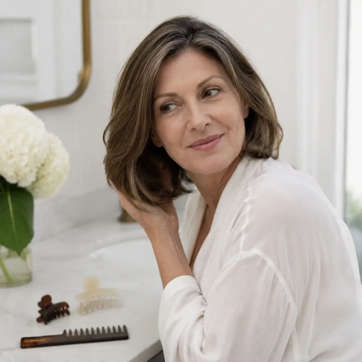 Realistic editorial photo of a woman over 50 with a medium haircut styled without heat, hair clips and wide-tooth comb o