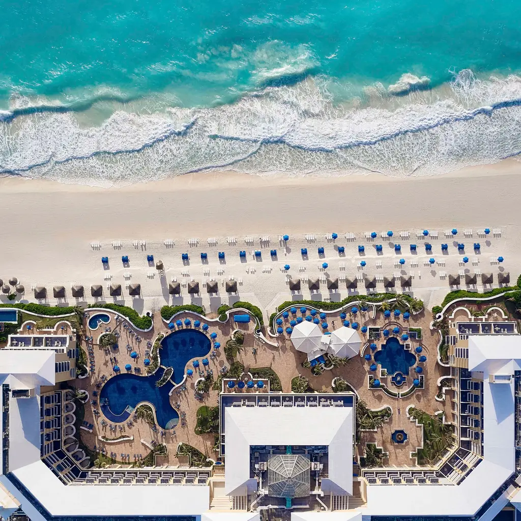 Kempinski Hotel Cancun beside its pool and white-sand beach