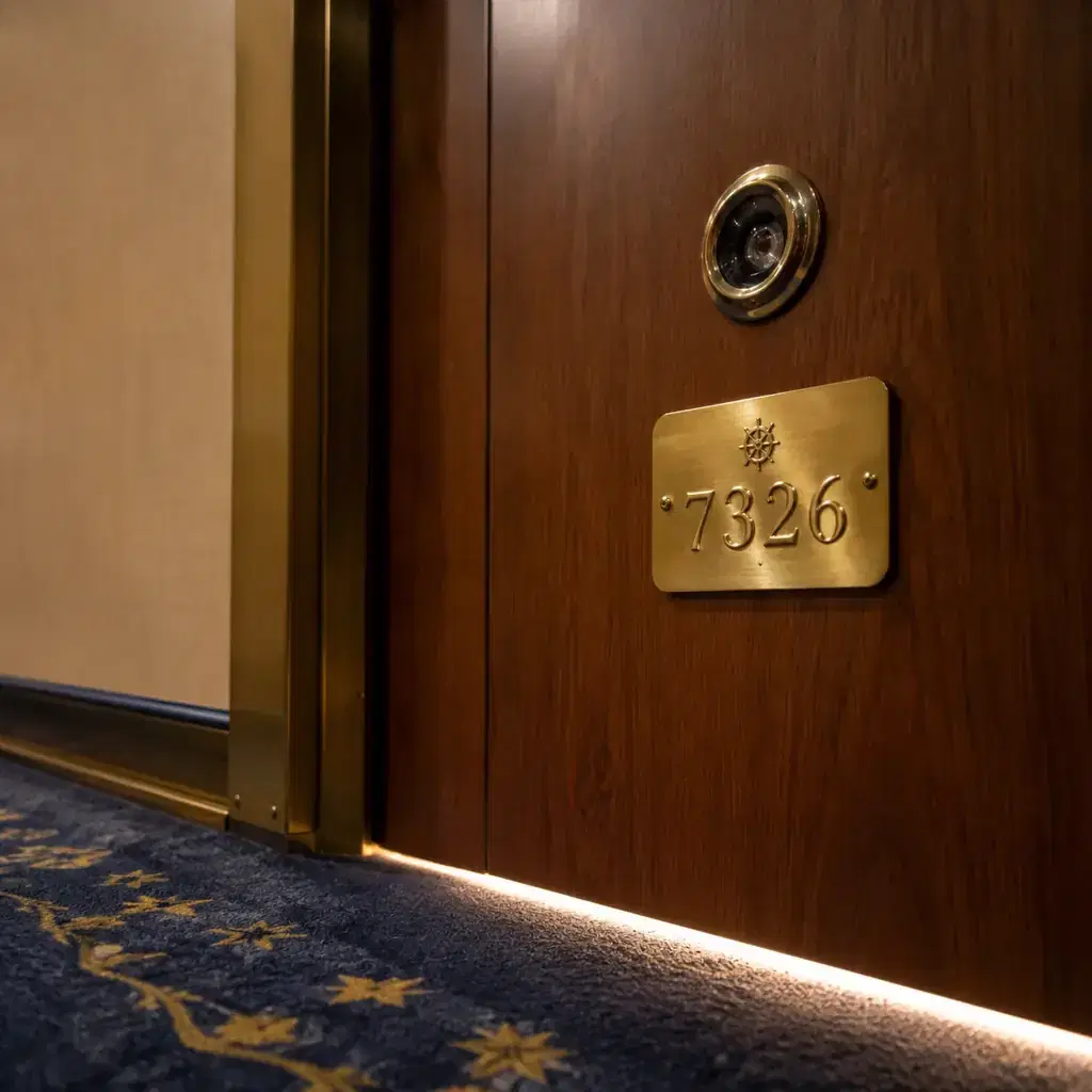 Realistic editorial close-up of a woman traveler looking through a hotel door peephole from inside, softly lit room and