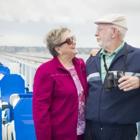 Couple in their eighties enjoying the view from a cruise ship deck