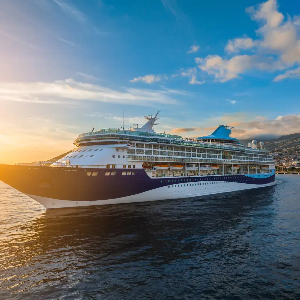 A large cruise ship sailing on blue water in evening sunlight