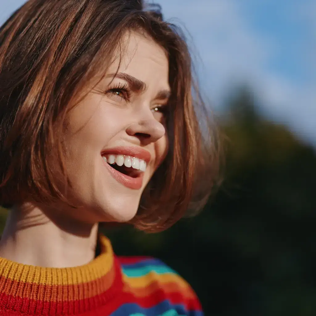 A woman outdoors with a jaw-length brown bob