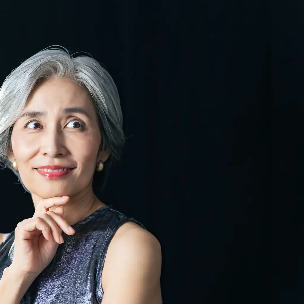 A woman with a softly parted silver haircut