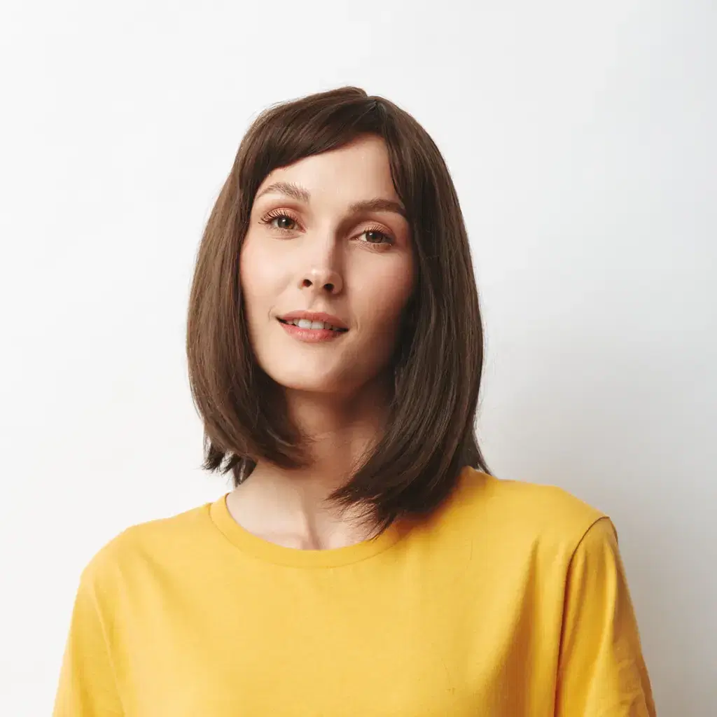 A woman in a yellow shirt with a straight shoulder-skimming bob