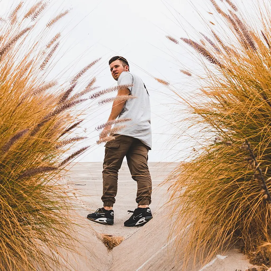 A traveler wearing sneakers on a sandy beach