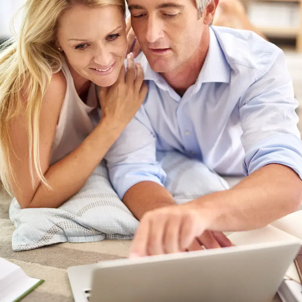 A couple researching a trip together on a laptop