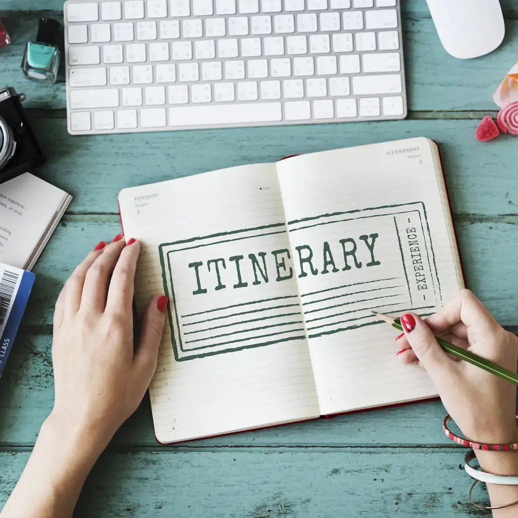 A traveler planning an itinerary in a notebook