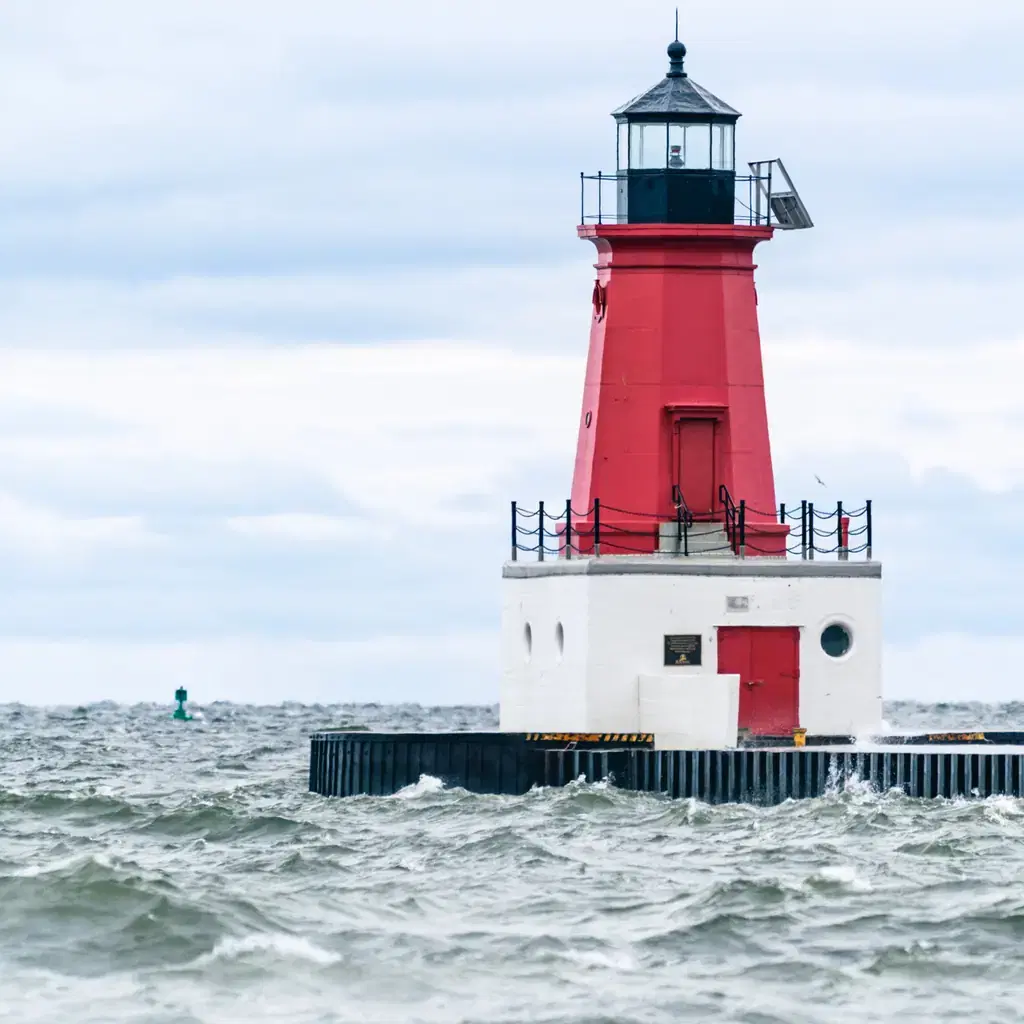 Menominee Pierhead Lighthouse stands in choppy Lake Michigan water.