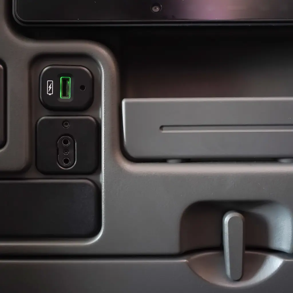 A USB charging port in an aircraft seat-back panel