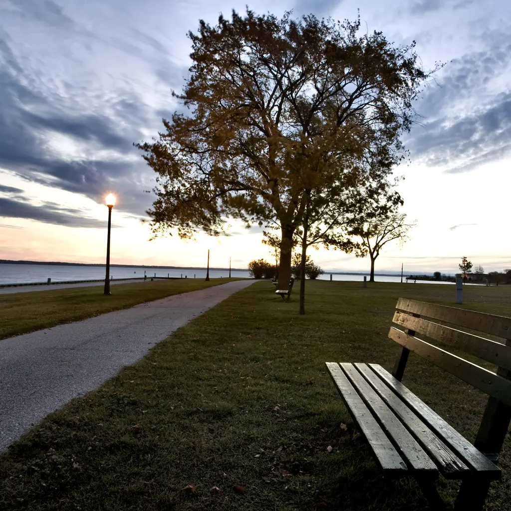 A bench and lakeside path at sunrise in Escanaba, Michigan.