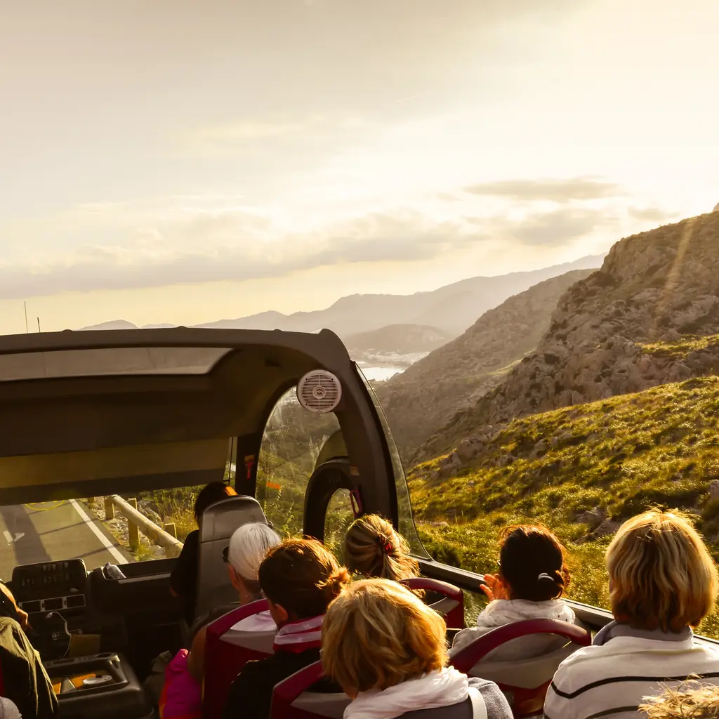 Passengers taking a scenic excursion in an open-top coach
