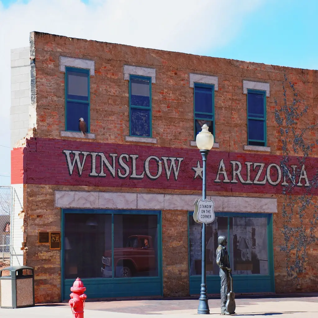 Historic brick storefronts and the Standin on the Corner landmark in Winslow, Arizona.