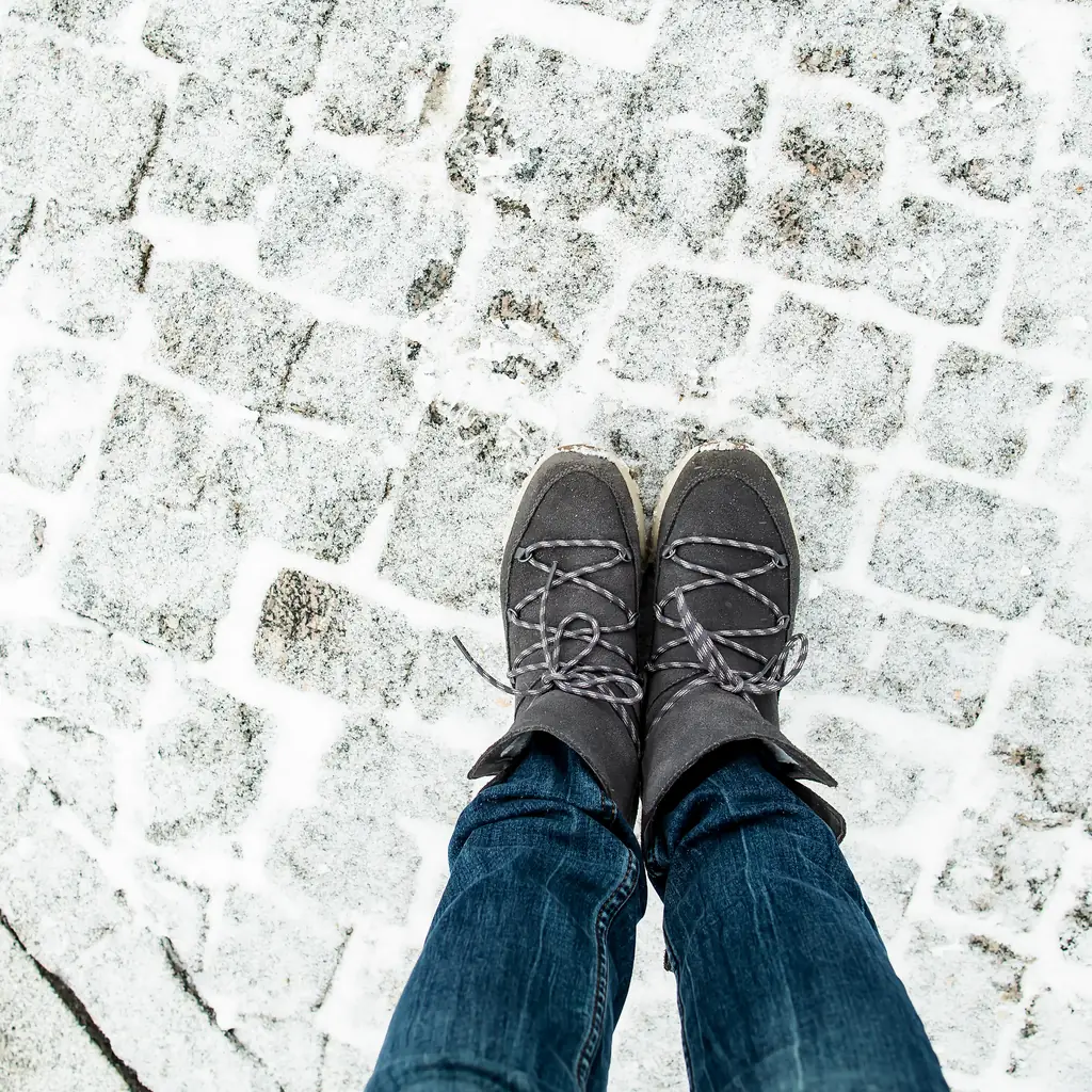 Leather-soled boots on wet cobblestones in an old European street