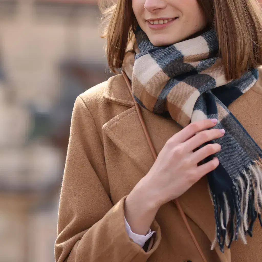 An oversized plaid blanket scarf wrapped thickly over a winter coat