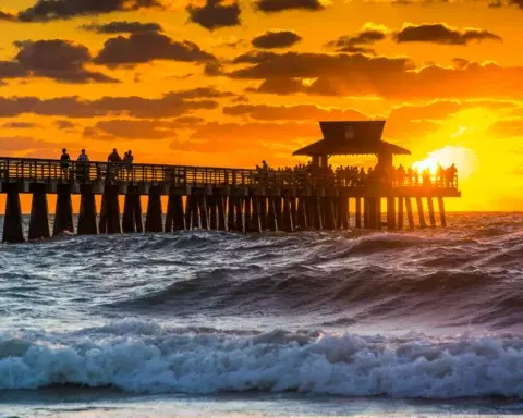The wooden Naples Pier stretching into the Gulf of Mexico under a clear sky