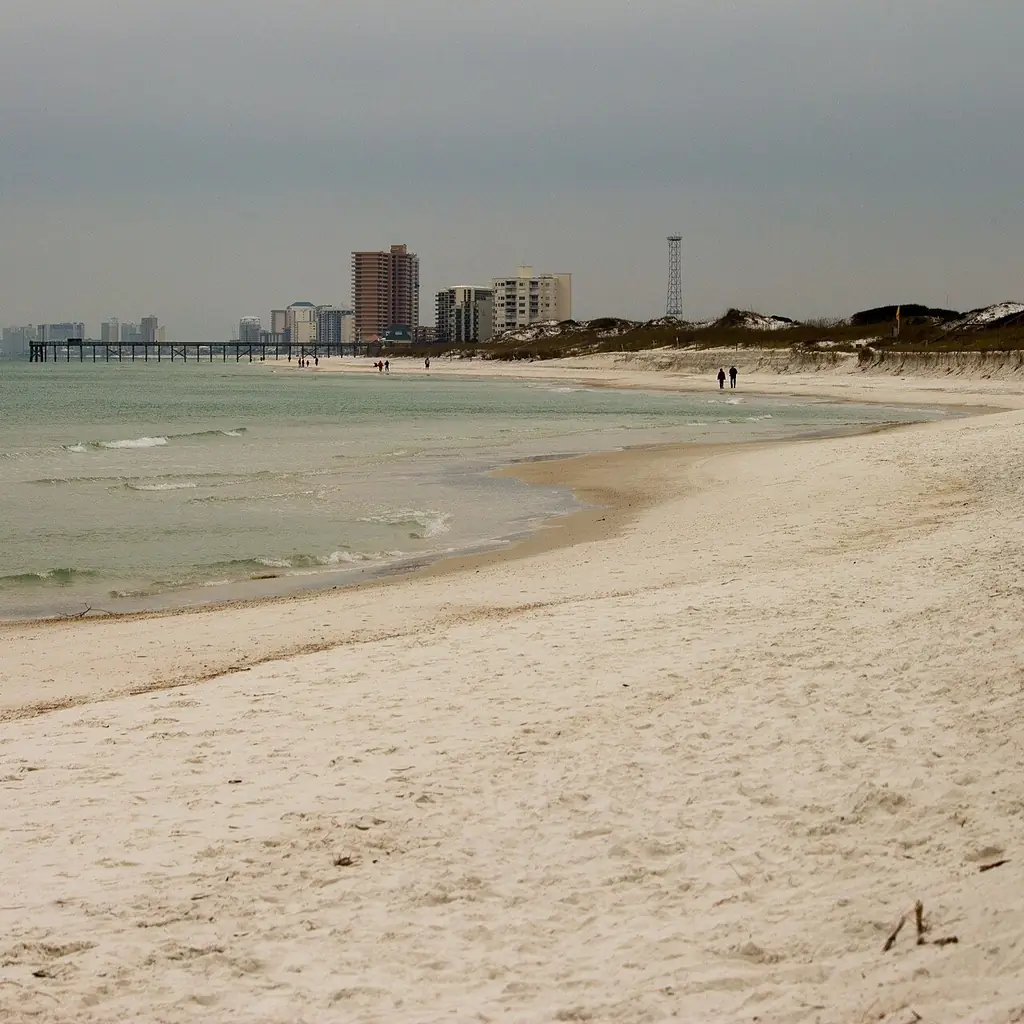 Panama City Beach pier and empty white sand under a gray winter sky
