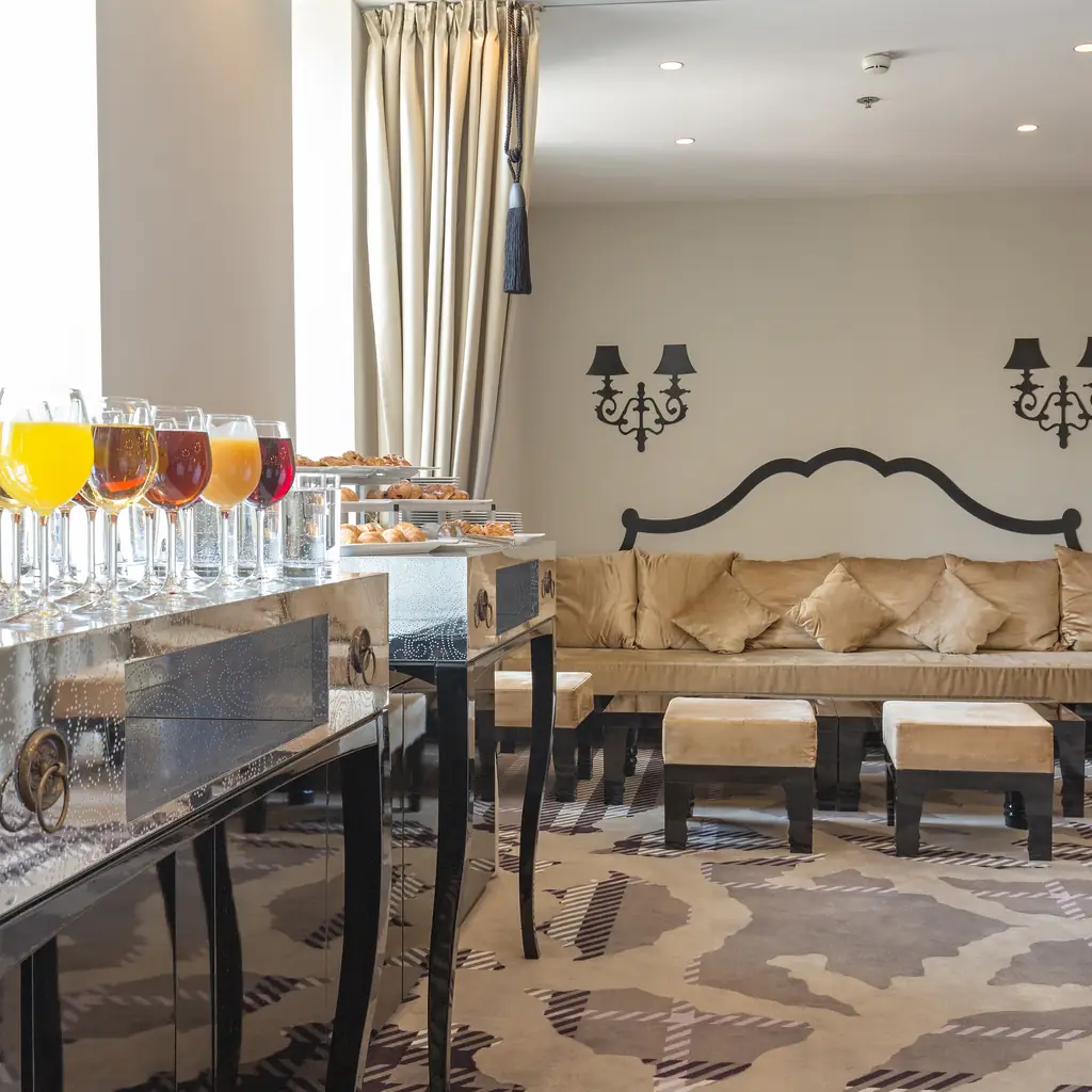 An elegant hotel lounge seating area with a sofa and chandeliers, illustrating how the word suite is used loosely across the industry.