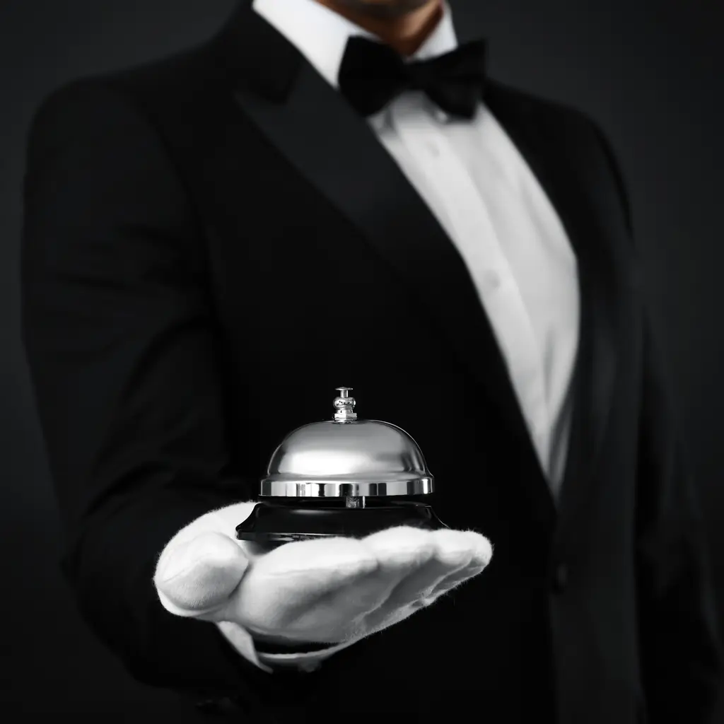 A butler holding a service bell, illustrating full butler service at a resort's top room tier.