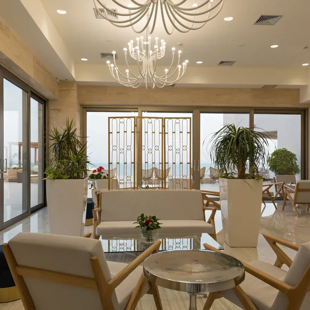 An elegant hotel lounge interior with a chandelier and ocean view, illustrating a club-level lounge offered instead of a personal butler.