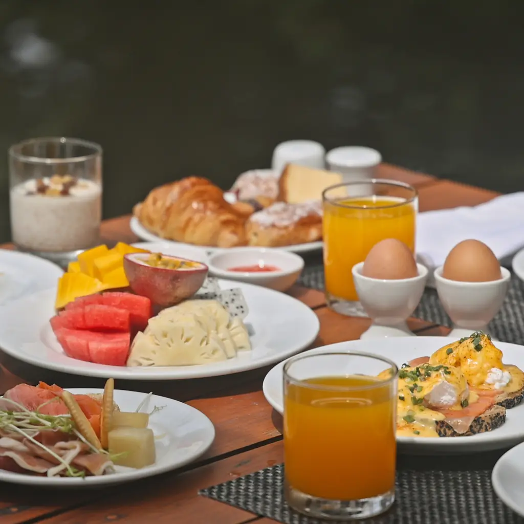 A luxury breakfast spread with eggs, fruit, and croissants, illustrating the food and beverage perk specific to a club lounge tier.