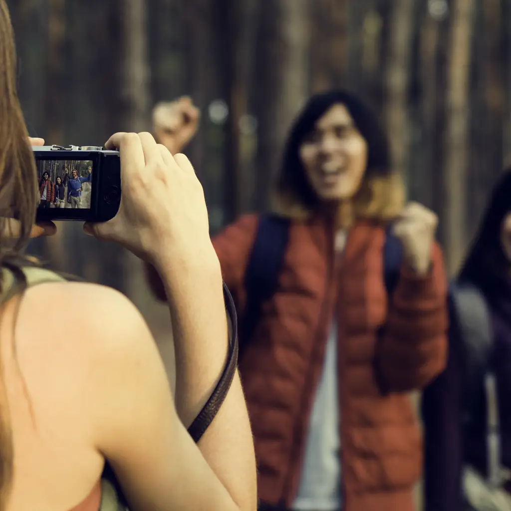 A small group of friends taking photos while trekking outdoors, illustrating a premium line built around a single traveler segment.
