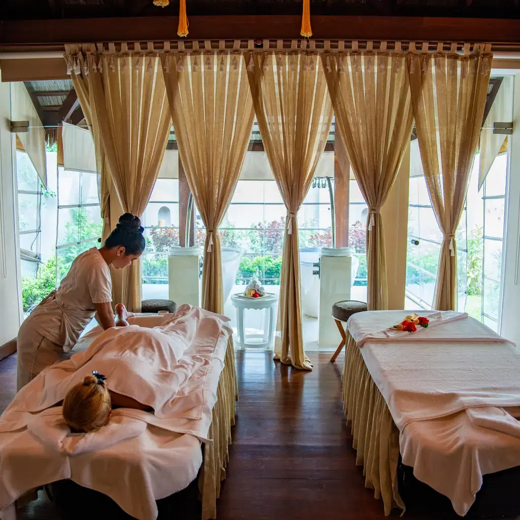 An open-air spa and massage room at a resort, illustrating spa access folded into a service tier.