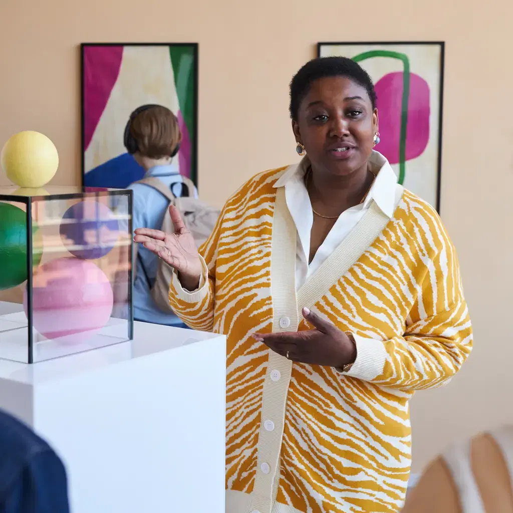 A museum guide explaining a modern art exhibit to a small group, illustrating the local-specialist guide model.