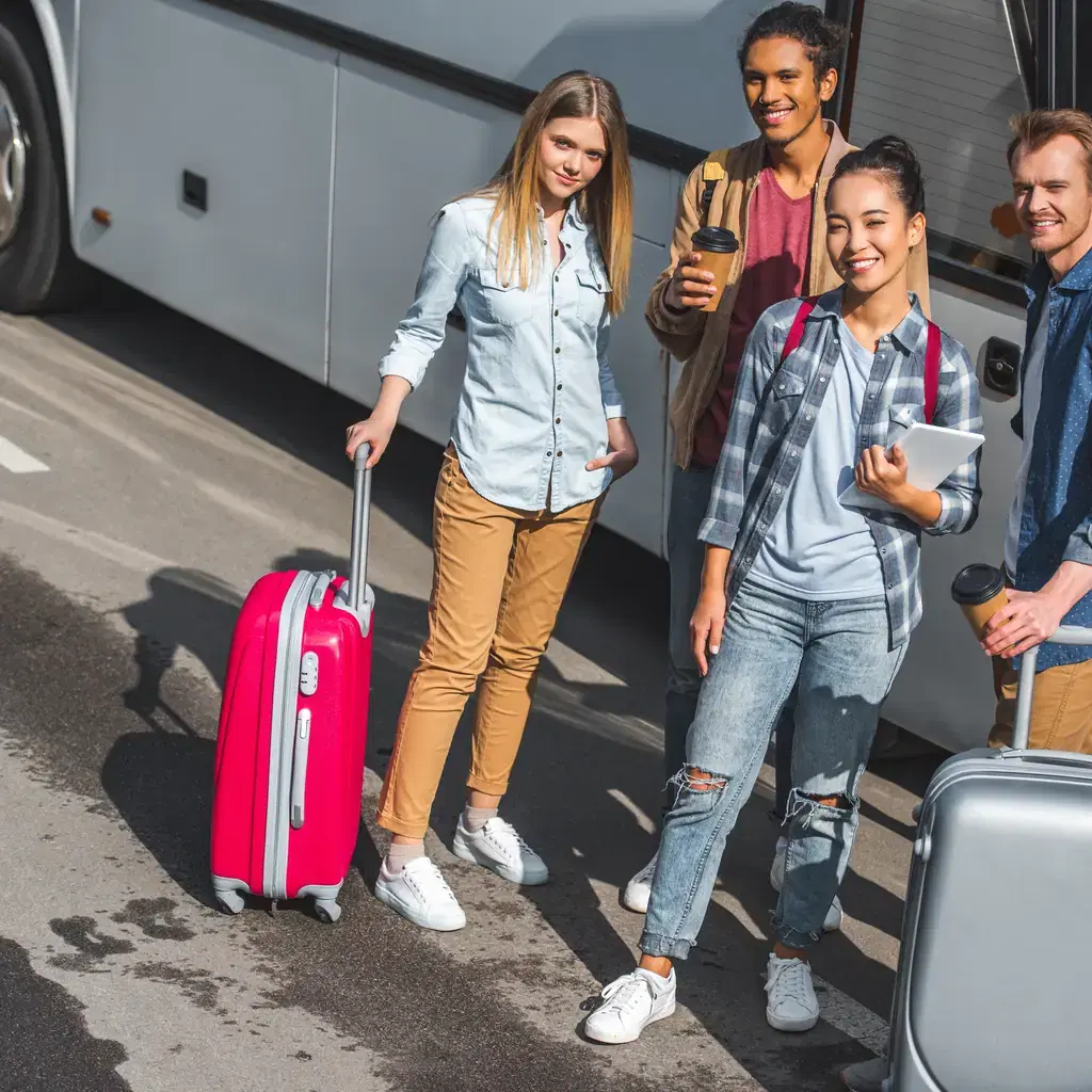 A group of travelers with wheeled luggage boarding a shuttle bus, illustrating a bus-only resort's transportation.